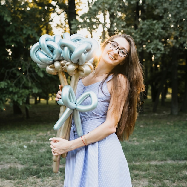 Feliz cumpleaños mujer al aire libre con globos