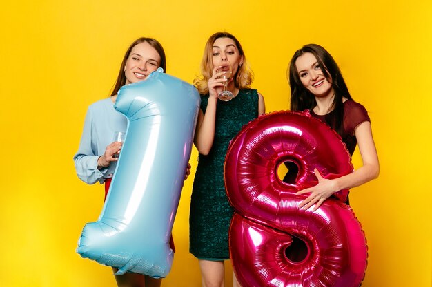 Feliz cumpleaños. Tres mujeres bonitas felices en vestido de moda celebrando un aniversario