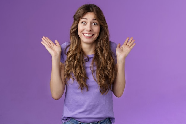 Foto gratuita feliz despreocupada entusiasta chica de pelo rizado despreocupada encogiéndose de hombros extendió las manos hacia los lados sonriendo descuidado desinteresado otros problemas indiferente sin problemas negar participación