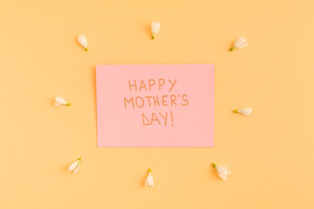 Feliz dia de las madres felicitaciones en papel entre flores.