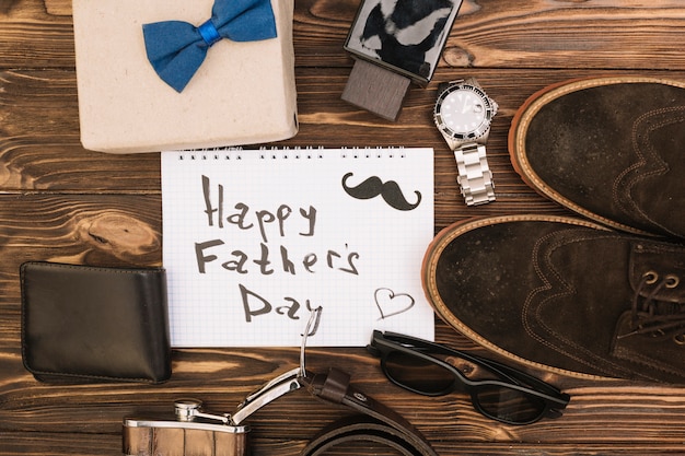 Feliz día del padre título en papel cerca de zapatos y accesorios masculinos