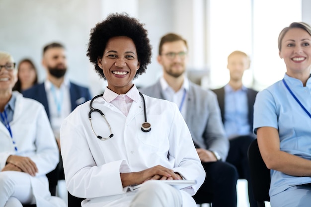 Feliz doctora negra asistiendo a un evento educativo en el centro de convenciones