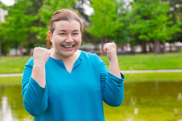 Feliz emocionada mujer de talla grande celebrando el éxito