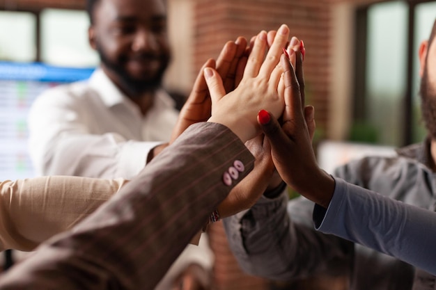 Feliz y emocionado equipo de negocios celebrando una asociación exitosa disfrutando juntos en la oficina de inicio. Diversos empresarios sonrientes logran colaboración empresarial. Concepto de victoria