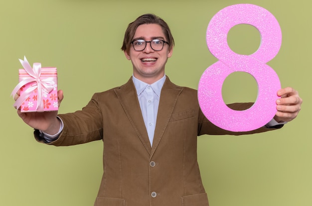 Foto gratuita feliz y emocionado joven con gafas sosteniendo