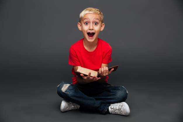 Feliz emocionado niño niño leyendo libro.