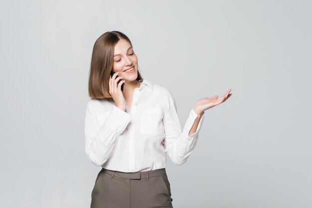 Feliz empresaria confiada hablando por teléfono móvil aislado