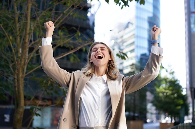 Foto gratuita feliz empresaria gritar de alegría levantar las manos en celebración animando gesto lograr meta y tr