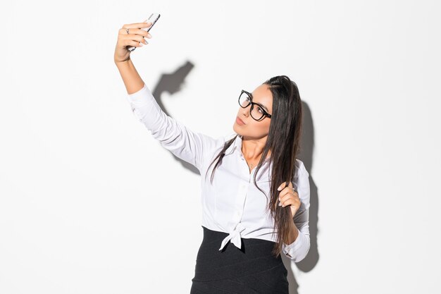 Feliz empresaria haciendo foto selfie en smartphone en blanco