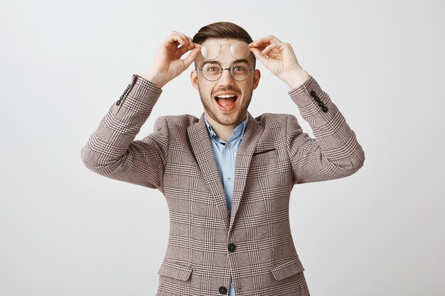 Feliz empresario probándose gafas nuevas en la tienda de óptica