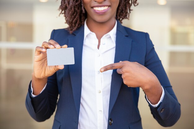 Feliz exitosa mujer de negocios que muestra la tarjeta de identificación