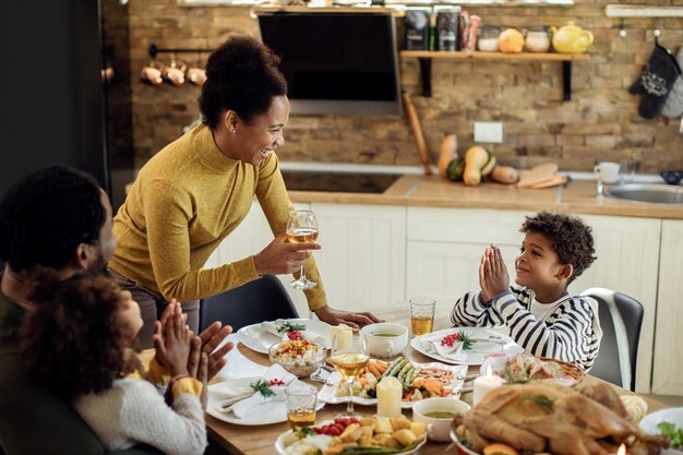 Feliz familia afroamericana disfrutando del almuerzo de Navidad en la mesa de comedor