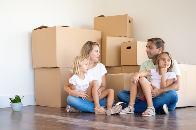 Feliz familia caucásica sentada en el piso con niños