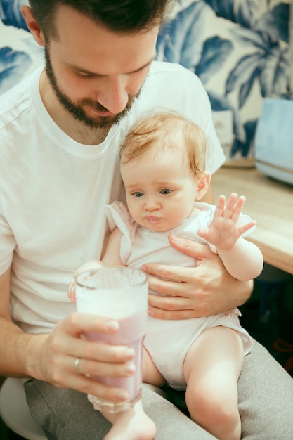 La feliz familia caucásica sonriente en la cocina preparando el desayuno