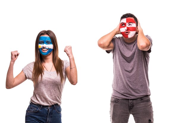 Feliz fanático del fútbol de Argentina celebra la victoria sobre el molesto fanático del fútbol de Croacia con la cara pintada