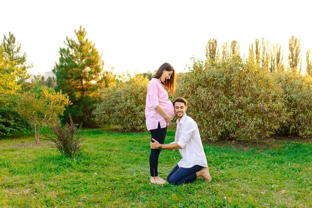 Feliz futuro padre escucha a su bebé sonriendo