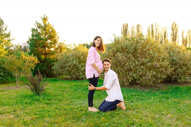 Feliz futuro padre escucha a su bebé sonriendo