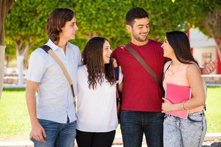 Foto gratuito feliz grupo de adultos jóvenes pasando el rato en la escuela y divirtiéndose juntos