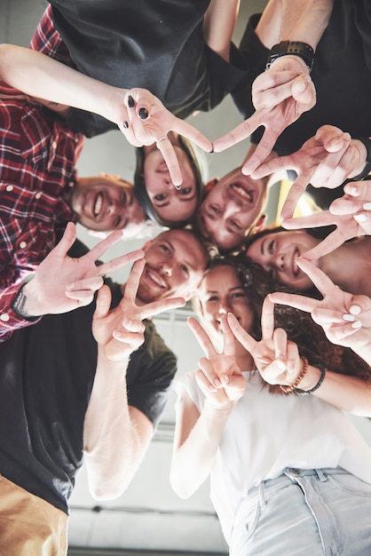 Feliz grupo de amigos con las manos juntas en el medio