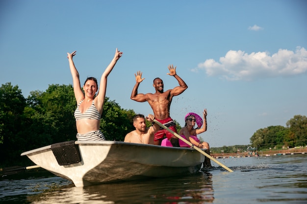 Feliz grupo de amigos que se divierten mientras se ríen y nadan en el río