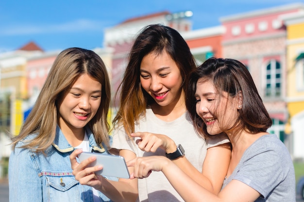 Feliz grupo de mujeres asiáticas jóvenes en el estilo de vida de la ciudad jugando y conversando