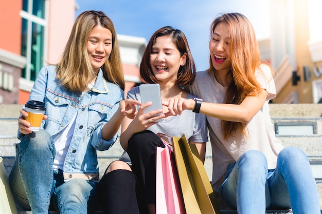 Feliz grupo de mujeres asiáticas jóvenes que viven en la ciudad jugando y conversando