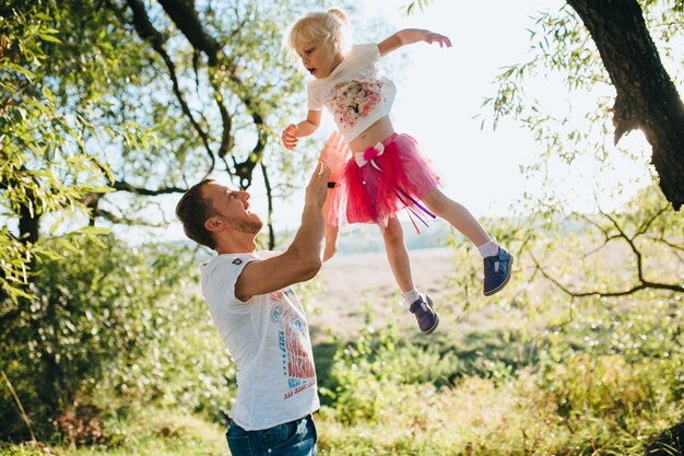 Feliz hermosa familia en el gran jardín en el tiempo del amanecer