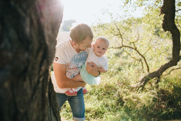 Feliz hermosa familia en el gran jardín en el tiempo del amanecer