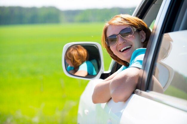 Foto gratuita feliz hermosa mujer en coche nuevo blanco en la naturaleza