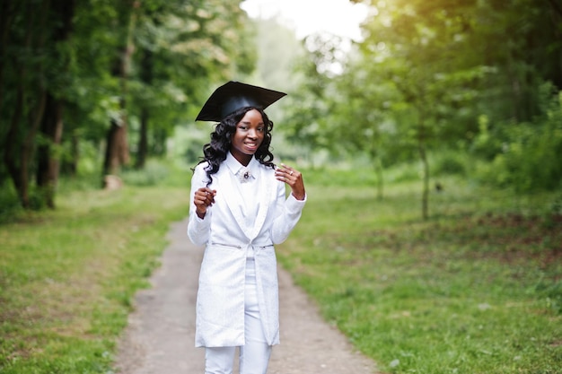 Feliz hermosa niña afroamericana negra con graduados de sombrero