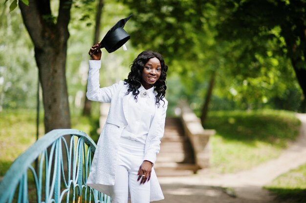 Feliz hermosa niña afroamericana negra con graduados de sombrero