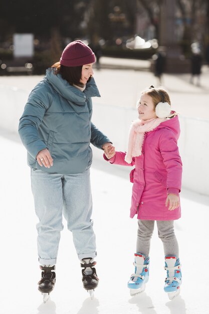 Feliz hija y madre patinaje sobre hielo