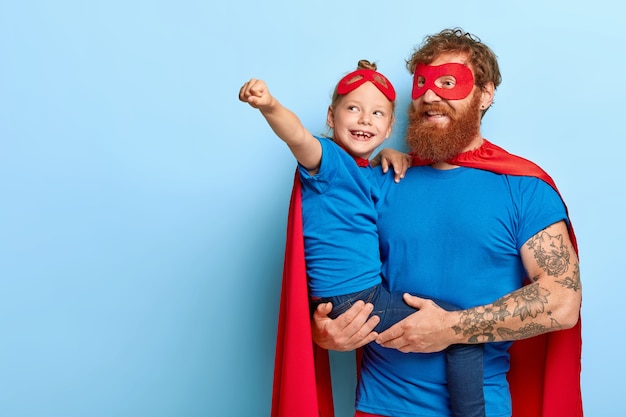 Foto gratuita feliz hija y padre tienen poder sobrenatural, la niña hace un gesto de vuelo