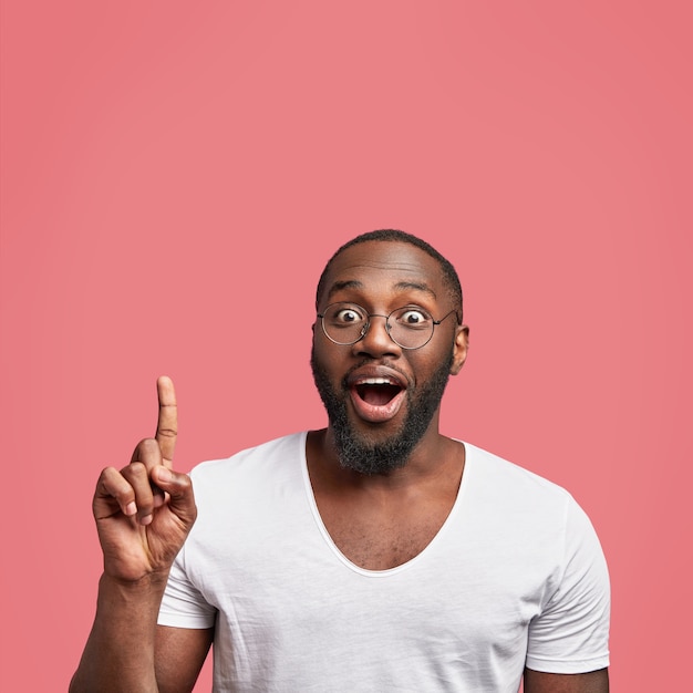 Feliz hombre adulto afroamericano positivo tiene piel oscura y barba espesa