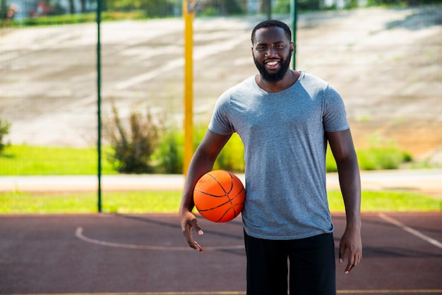 Feliz hombre barbudo en cancha de baloncesto