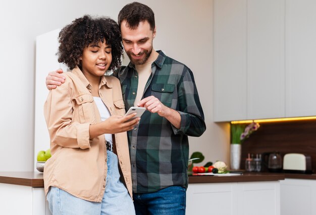 Feliz hombre y mujer mirando por teléfono