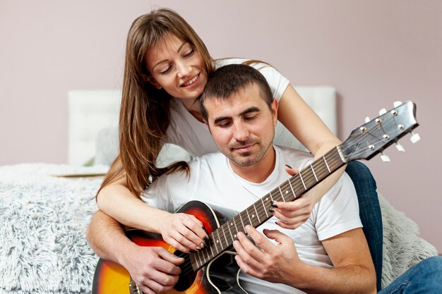 Feliz hombre y mujer tocando la guitarra