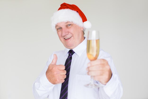 Feliz hombre de negocios con sombrero de Santa con champán