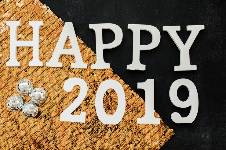 Foto gratuito feliz inscripción 2019 con lentejuelas naranjas.