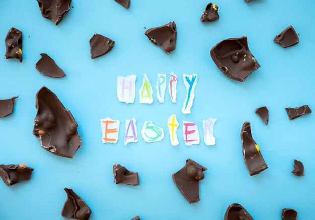 Feliz inscripción de Pascua con trozos de chocolate.