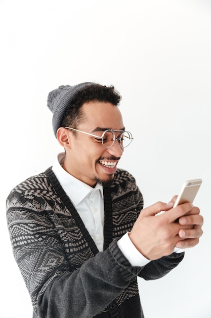 Feliz joven africano chateando por teléfono.