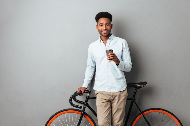 Feliz joven africano tomando café.