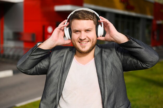 Feliz joven con auriculares en sus oídos