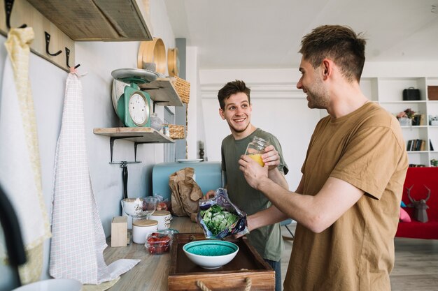 Feliz joven ayudando mutuamente para preparar el desayuno en casa