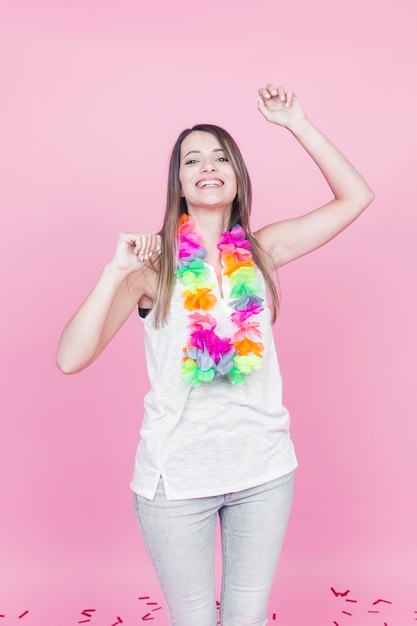 Feliz joven bailando sobre fondo rosa