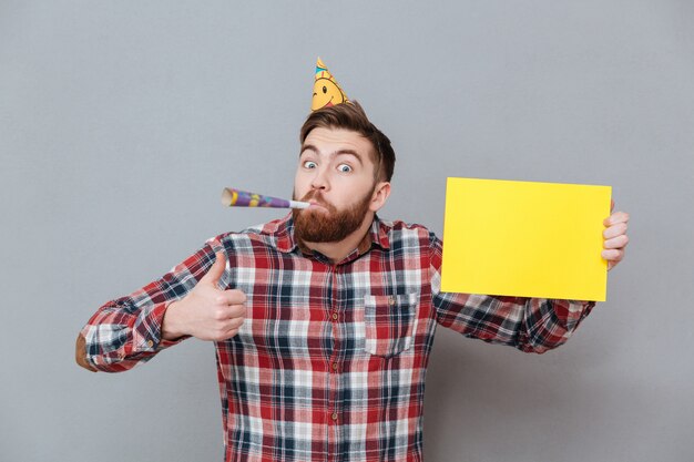 Feliz joven barbudo cumpleaños hombre con tablero en blanco