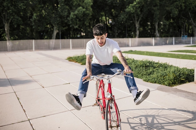 Feliz joven ciclista disfrutando de paseo en su bicicleta