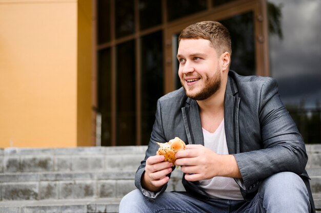 Feliz joven con comida en sus manos