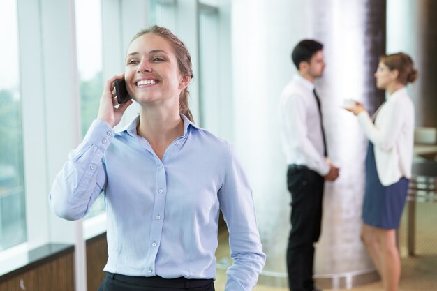 Feliz joven empresaria hablando por teléfono celular