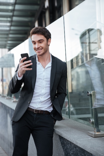 Feliz joven empresario caminando cerca del centro de negocios.